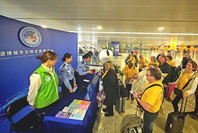 移民管理警察在進博會城市文明志愿服務站 為外籍旅客提供通關與游學咨詢服務